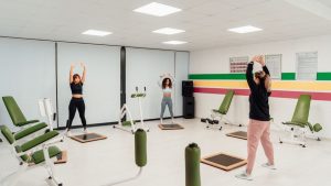Three women engage in a workout session in a brightly lit, modern fitness studio in Yalova, Türkiye.