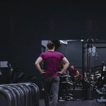 Man in a gym with fitness equipment, highlighting a healthy lifestyle.
